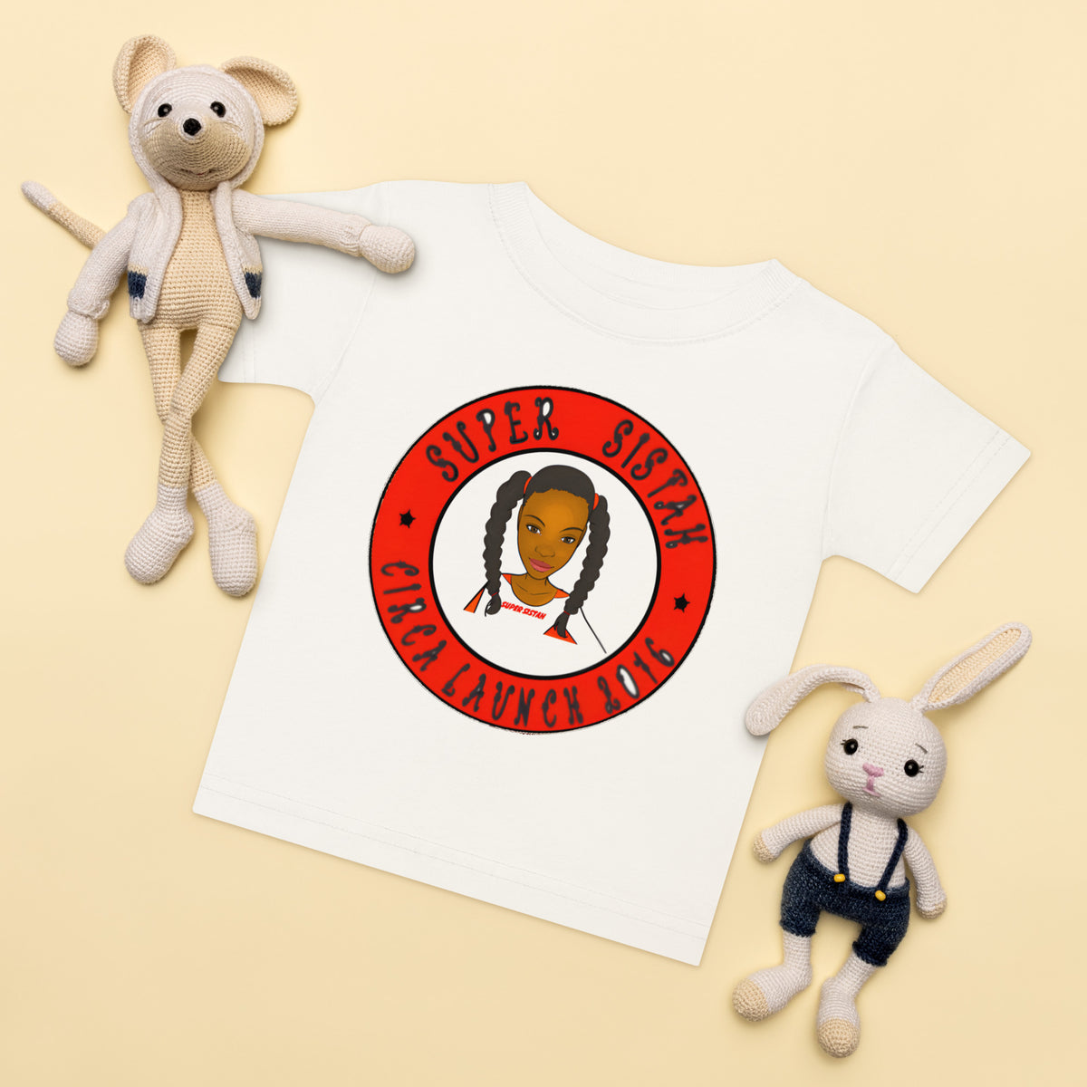 White t-shirt with 'Super Sisbah' graphic, surrounded by two plush toys on a beige background